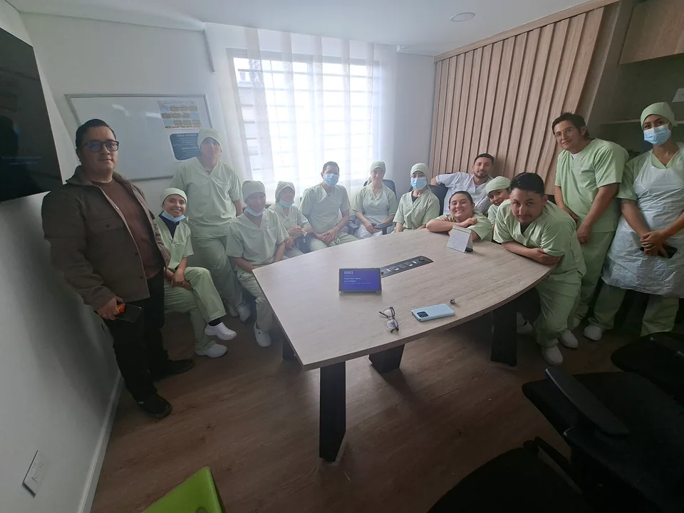 Instructor y personal de salud reunidos alrededor de una mesa al finalizar una capacitación de seguridad y salud en el trabajo.
