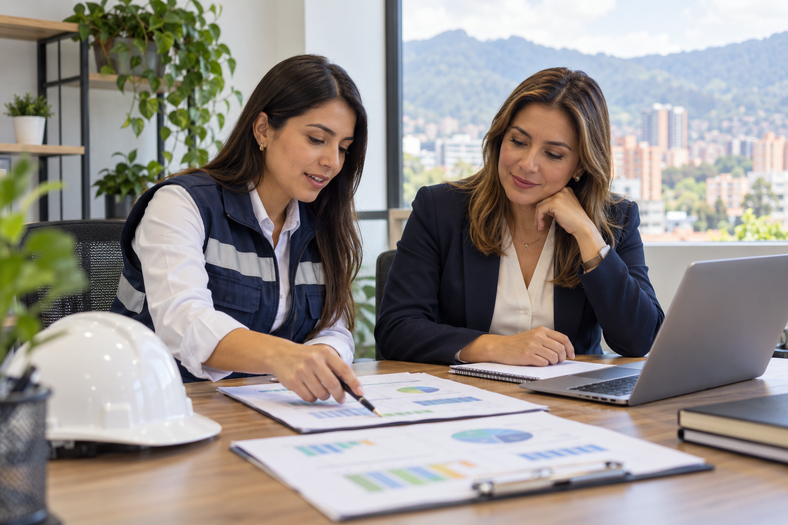 Asesora de SST y gerente revisan juntos un plan de trabajo en una empresa colombiana.